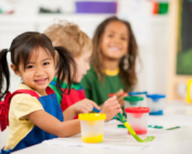 Children engaged in an art activity at Early Achievers Preschool Hawaii, painting with bright colors.