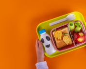 Early Achievers Preschool lunch tray with healthy Halloween-themed sandwich, vegetables, and ghost-decorated milk bottle for fun nutritious eating