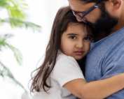 Father comforting child with separation anxiety at Early Achievers Preschool Hawaii, supporting a smooth preschool transition.