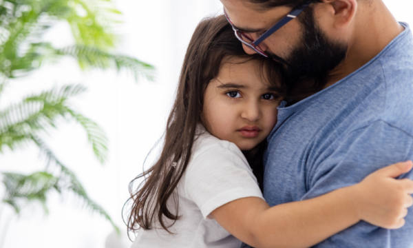 Father comforting child with separation anxiety at Early Achievers Preschool Hawaii, supporting a smooth preschool transition.

