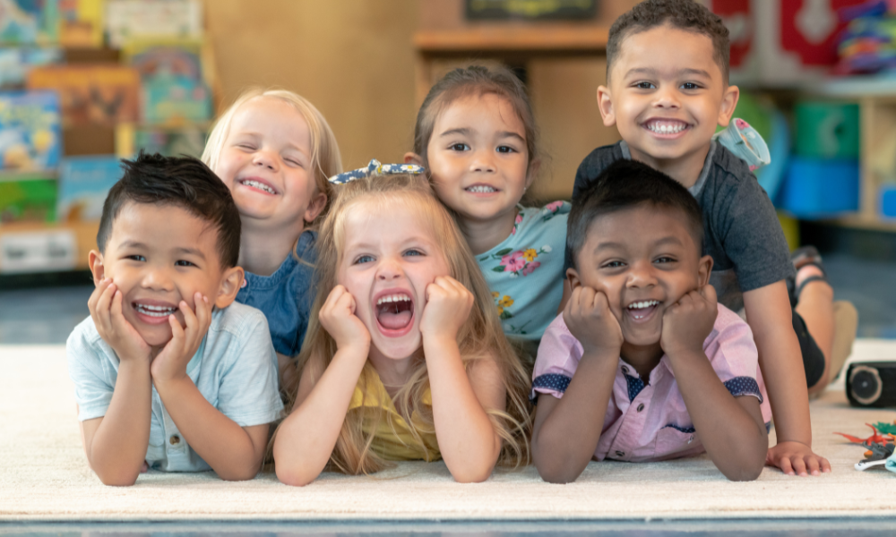 Diverse group of preschoolers smiling and learning together, reflecting Early Achievers Preschool’s commitment to Hawaiian culture and community values.