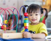 Preschool student engaging with interactive bead maze toy to build problem solving and cognitive skills in early learning environment, Early Achievers Preschool Hawaii